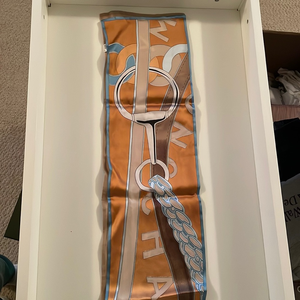 Longchamp silk scarf in orange w blue & brown accents. 64” long x 7.5” wide